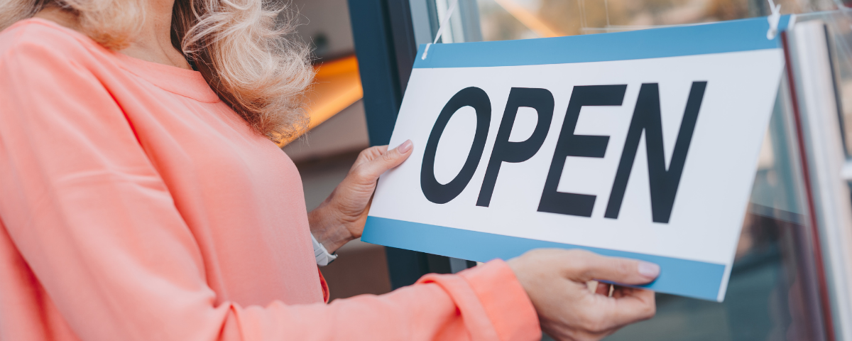 sign OPEN held by a person